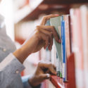 Ragazza in biblioteca cerca un libro