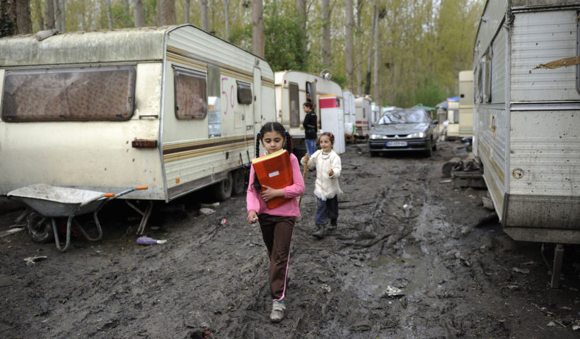 Bambine con i libri di scuola in un campo rom