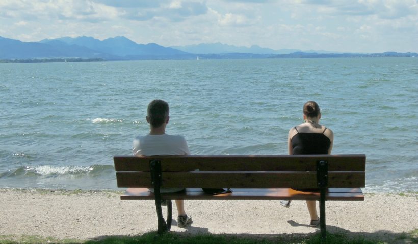 Una coppia si lascia, seduta su una panchina davanti al mare